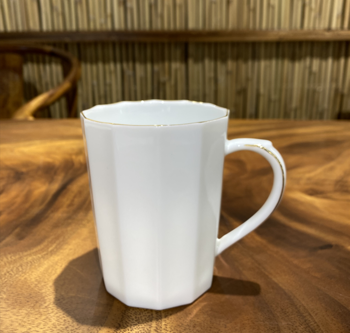 White jade porcelain cup with golden edges and corners